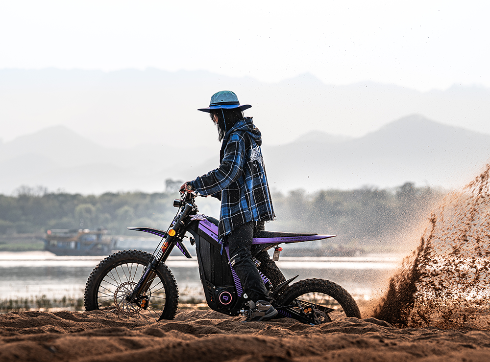 Lynx 2026 violette avec son rider sur le sable, montagnes en arrière-plan